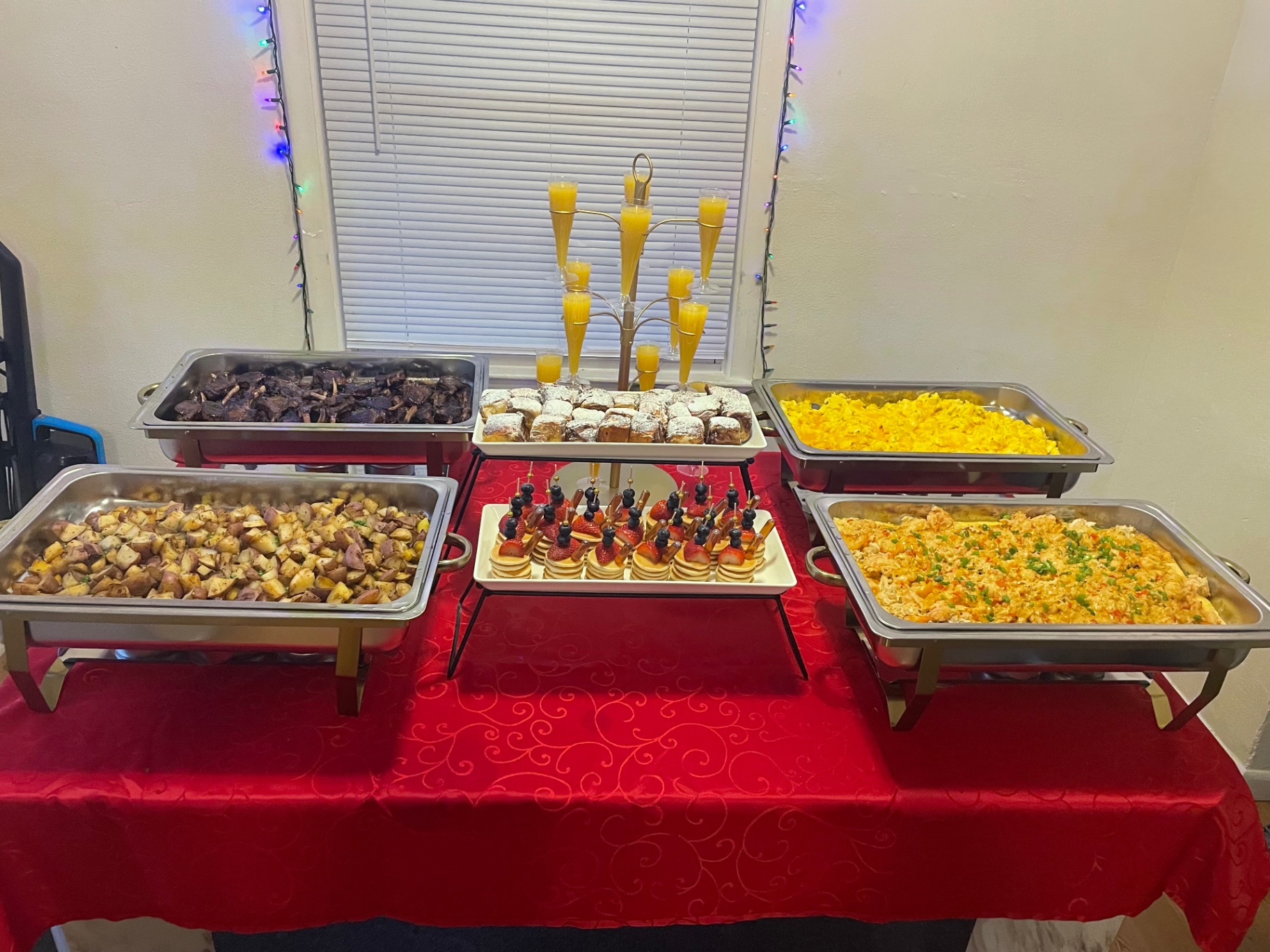 Catered brunch buffet with chafing dishes of lamb chops, eggs and potatoes